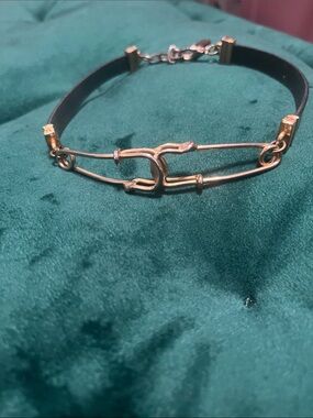Vintage gold-tone choker with distinct safety-pin style clasp and leather strap
